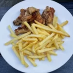 Spiced fried chicken wings with French fries
